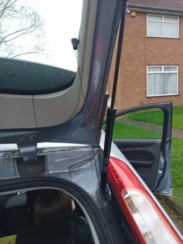 Close-up view of installed ford focus boot struts holding the tailgate open.