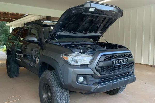 A lifted Toyota Tacoma truck showing the newly installed Sokietech hood struts.